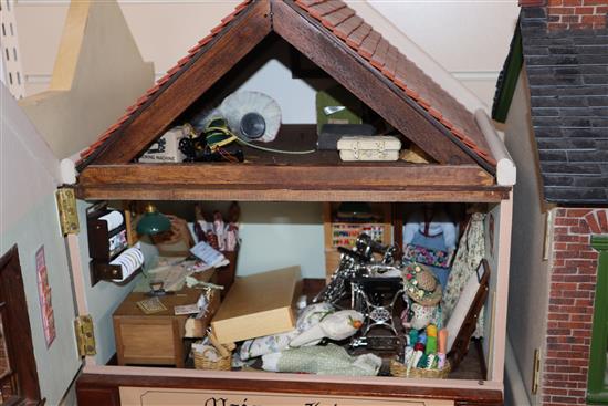 A group of three dolls house models of shops with figures and accessories and an unfinished dolls house